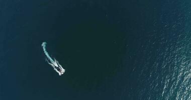 Aerial top view of a white pleasure boat on a summer day. Powerboat turn loop eight on the sea making infinity future concept. photo