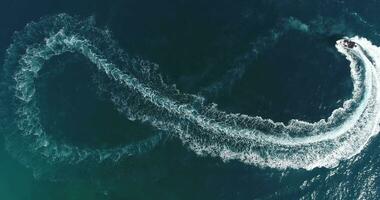 Aerial top view of a white pleasure boat on a summer day. Powerboat turn loop eight on the sea making infinity future concept. photo