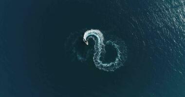 Aerial top view of a white pleasure boat on a summer day. Powerboat turn loop eight on the sea making infinity future concept. photo