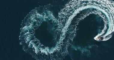 Aerial top view of a white pleasure boat on a summer day. Powerboat turn loop eight on the sea making infinity future concept. photo