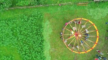 Carnival Merry Go Round aerial top view. Drone tracking rotation shoot. photo