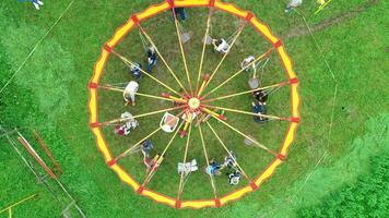 Carnival Merry Go Round aerial top view. Drone tracking rotation shoot. photo