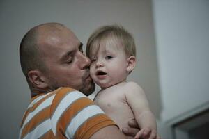 father holding and kissing newborn little baby photo