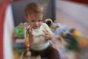 cute  little  baby playing in mobile  bed photo