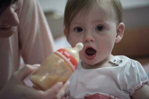 little baby  drinking juice  from bottle photo