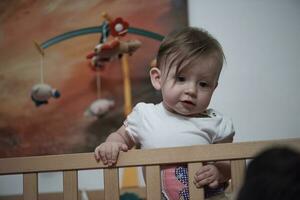 cute  little one year old baby and making first steps in bed photo