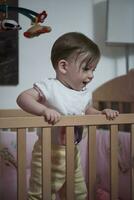 cute  little one year old baby and making first steps in bed photo