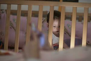 cute  little one year old baby and making first steps in bed photo