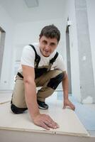 Worker Installing New Laminated Wooden Floor photo