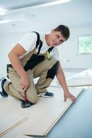 Professional Worker Installing New Laminated Wooden Floor photo