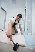 Professional Worker Installing New Laminated Wooden Floor photo