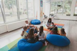 leyendo hora en un elemental colegio o jardín de infancia, un profesor lee un libro a niños en un elemental colegio o jardín de infancia. el concepto de preescolar educación. selectivo atención foto