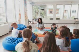 leyendo hora en un elemental colegio o jardín de infancia, un profesor lee un libro a niños en un elemental colegio o jardín de infancia. el concepto de preescolar educación. selectivo atención foto