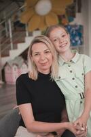 A cute little girl kisses and hugs her mother in preschool photo