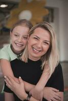 un linda pequeño niña Besos y abrazos su madre en preescolar foto