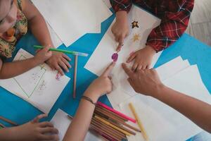 creativo niños durante un Arte clase en un guardería centrar o elemental colegio salón de clases dibujo con hembra maestro. foto