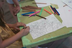 creativo niños sentado en un preescolar institución, dibujar y tener divertido mientras ellos obtener un educación foto