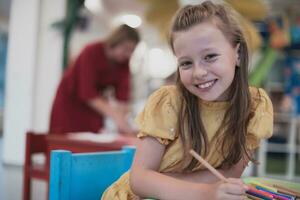 Creative kids sitting in a preschool institution, draw and have fun while they get an education photo