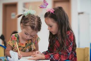 creativo niños sentado en un preescolar institución, dibujar y tener divertido mientras ellos obtener un educación foto