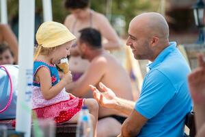 cute little girl eating ice cream with her young father photo