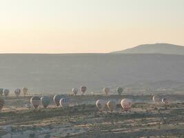 Aerial cinematic drone view of colorful hot air balloon flying over Cappadocia photo
