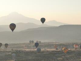 Aerial cinematic drone view of colorful hot air balloon flying over Cappadocia photo