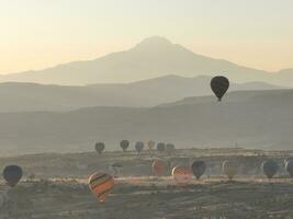 Aerial cinematic drone view of colorful hot air balloon flying over Cappadocia photo