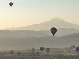 Aerial cinematic drone view of colorful hot air balloon flying over Cappadocia photo