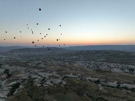 Aerial cinematic drone view of colorful hot air balloon flying over Cappadocia photo