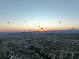 Aerial cinematic drone view of colorful hot air balloon flying over Cappadocia photo