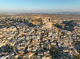 Aerial view of natural rock formations in the sunset, valley with cave houses in Cappadocia, Turkey. Natural landscape city lights at the night. photo