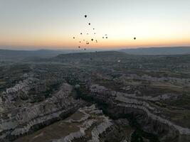 Aerial cinematic drone view of colorful hot air balloon flying over Cappadocia photo