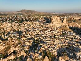 Aerial view of natural rock formations in the sunset, valley with cave houses in Cappadocia, Turkey. Natural landscape city lights at the night. photo