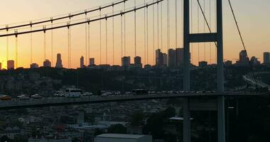 Istanbul Bosphorus Bridge and City Skyline in Background with Turkish Flag at Beautiful Sunset, Aerial slide orbiting and tracking shot photo