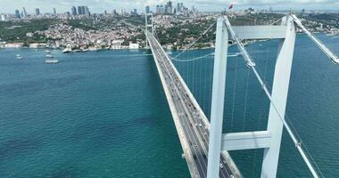 Estanbul bósforo puente y ciudad horizonte en antecedentes con turco bandera a hermosa atardecer, aéreo diapositiva orbital y rastreo Disparo foto