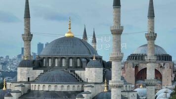 Establishing orbiting aerial drone shot of a Hagia Sophia Holy Grand Mosque with Bosphorus bridge and city skyline with a flag on the background in Fatih, Istanbul, Turkey at sunset. photo