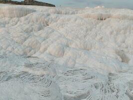 Pamukkale Travertines Cinematic Aerial Drone footage. Turkish famous white thermal bath with healthy clean water in a beautiful sunset. photo