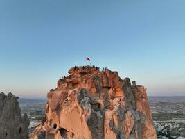 Aerial view of natural rock formations in the sunset, valley with cave houses in Cappadocia, Turkey. Natural landscape city lights at the night. photo