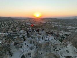 Aerial view of natural rock formations in the sunset, valley with cave houses in Cappadocia, Turkey. Natural landscape city lights at the night. photo