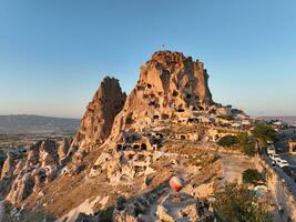 Aerial view of natural rock formations in the sunset, valley with cave houses in Cappadocia, Turkey. Natural landscape city lights at the night. photo