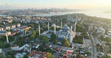 Istanbul, Turkey. Sultanahmet with the Blue Mosque and the Hagia Sophia with a Golden Horn on the background at sunrise. Cinematic Aerial view. photo