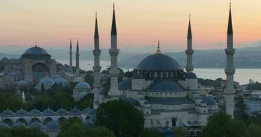 Estanbul, pavo. sultanahmet con el azul mezquita y el hagia Sofía con un dorado cuerno en el antecedentes a amanecer. cinematográfico aéreo vista. foto