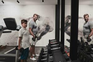 padre e hijo entrenan juntos en el gimnasio de casa. el concepto de vida sana. enfoque selectivo foto