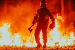 Firefighter at job. Firefighter in dangerous forest areas surrounded by strong fire. Concept of the work of the fire service photo