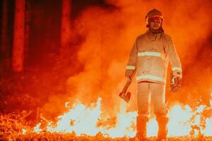 Firefighter at job. Firefighter in dangerous forest areas surrounded by strong fire. Concept of the work of the fire service photo