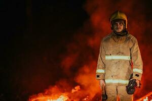 Firefighter at job. Firefighter in dangerous forest areas surrounded by strong fire. Concept of the work of the fire service photo