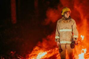 Firefighter at job. Firefighter in dangerous forest areas surrounded by strong fire. Concept of the work of the fire service photo