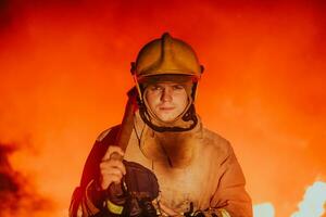 Firefighter at job. Firefighter in dangerous forest areas surrounded by strong fire. Concept of the work of the fire service photo