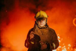 Firefighter at job. Firefighter in dangerous forest areas surrounded by strong fire. Concept of the work of the fire service photo