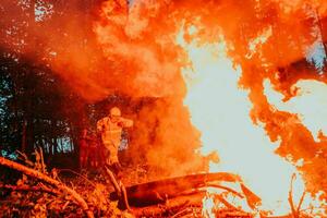 firefighter hero in action danger jumping over fire flame to rescue and save photo